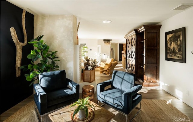 living area with an inviting chandelier and dark hardwood / wood-style floors