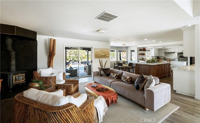 living room with light hardwood / wood-style flooring and a wood stove