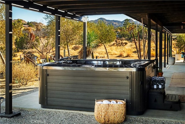 exterior details featuring a hot tub and a mountain view