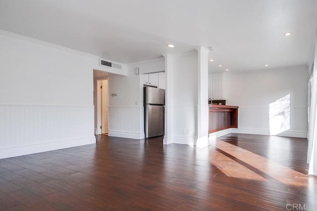 unfurnished living room with dark hardwood / wood-style flooring and crown molding