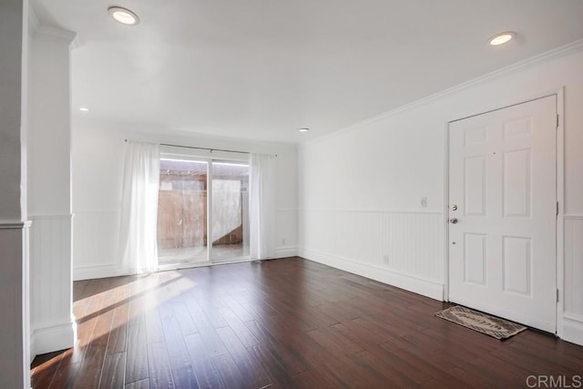 spare room featuring ornamental molding and dark hardwood / wood-style floors