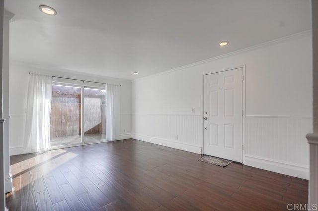 spare room featuring ornamental molding and dark hardwood / wood-style floors