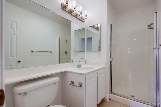 bathroom with vanity, toilet, a shower with shower door, and tile patterned flooring