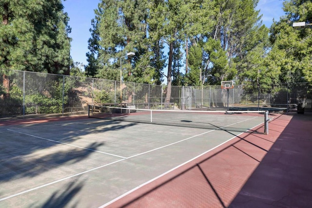 view of tennis court with basketball hoop