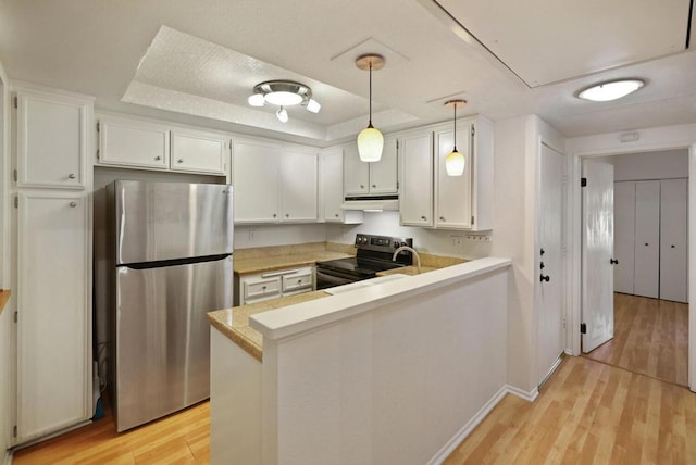 kitchen featuring stainless steel fridge, decorative light fixtures, black range with electric stovetop, and kitchen peninsula