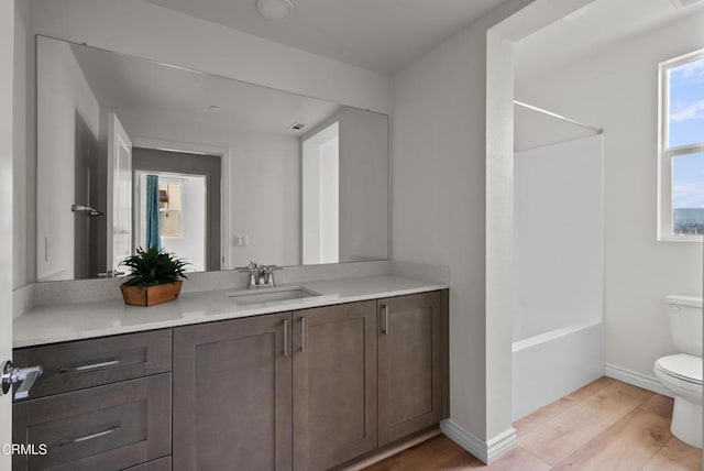 full bathroom featuring vanity, hardwood / wood-style flooring, tub / shower combination, and toilet