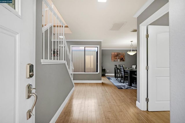 foyer entrance featuring hardwood / wood-style flooring and ornamental molding