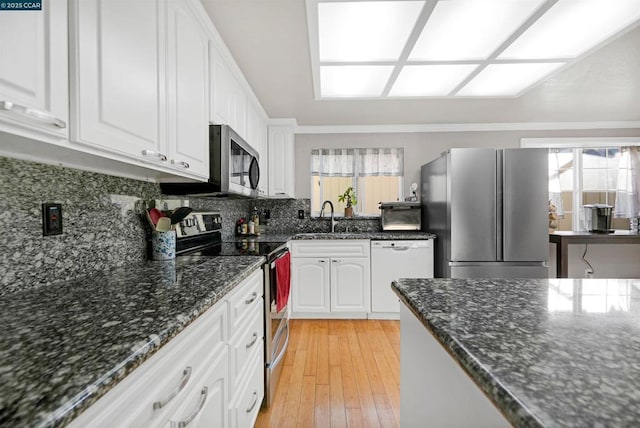 kitchen with sink, light hardwood / wood-style flooring, plenty of natural light, stainless steel appliances, and white cabinets