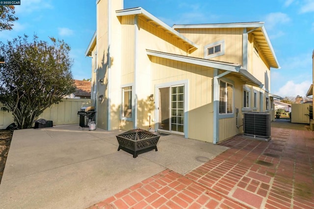 rear view of house featuring central AC unit, a fire pit, and a patio area