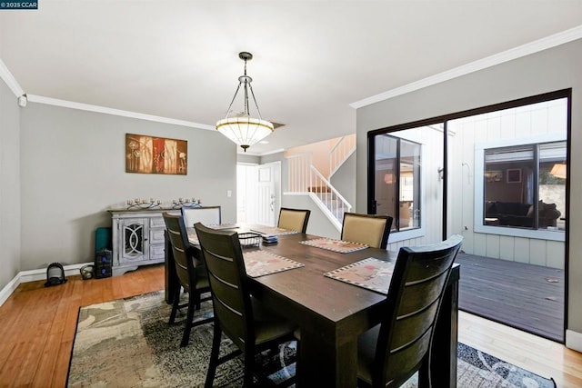 dining room with hardwood / wood-style flooring and crown molding