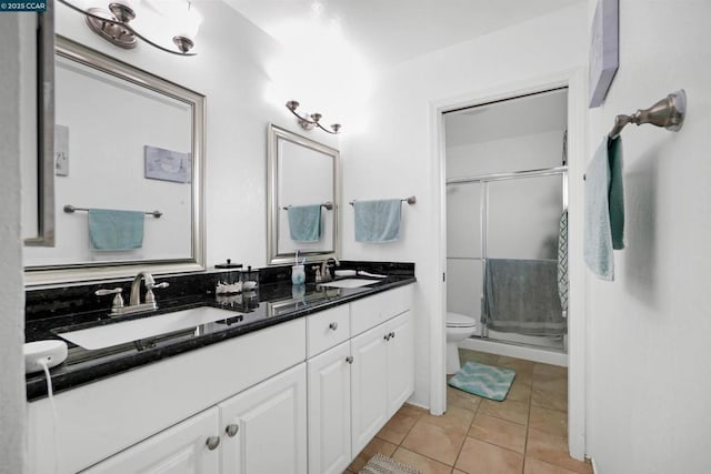 bathroom with vanity, toilet, tile patterned floors, and a shower with shower door