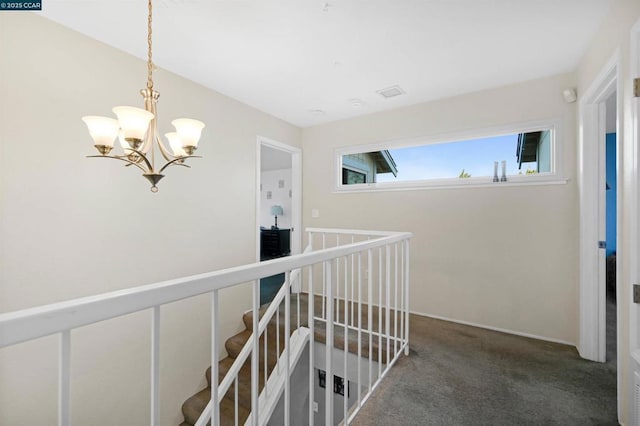 hall with a chandelier and carpet flooring