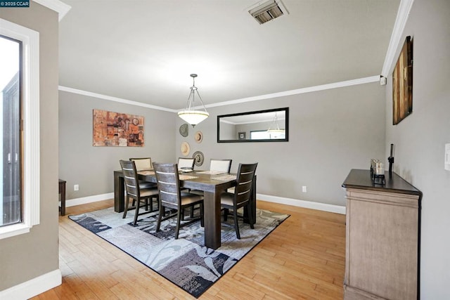 dining room with hardwood / wood-style floors and ornamental molding