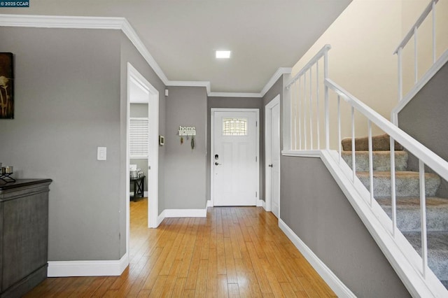 foyer entrance featuring crown molding and light wood-type flooring