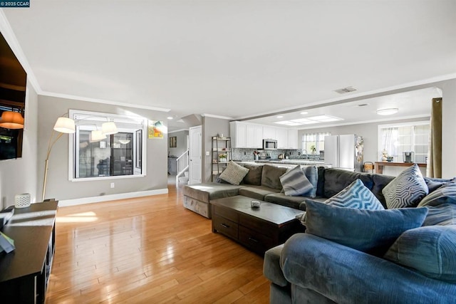 living room featuring crown molding and light hardwood / wood-style floors