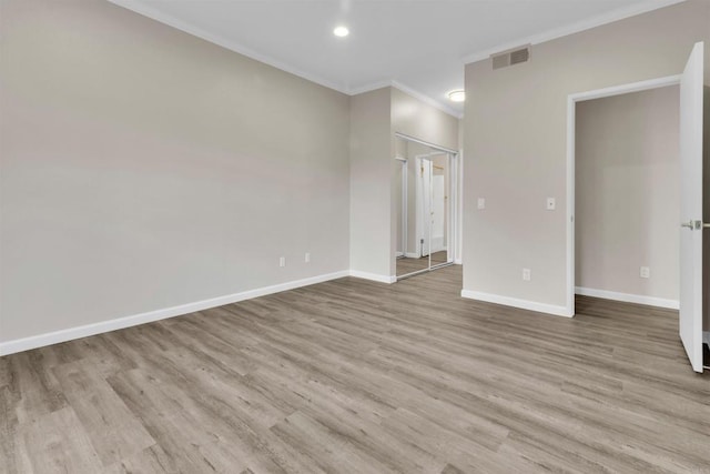 unfurnished room with crown molding and light hardwood / wood-style flooring