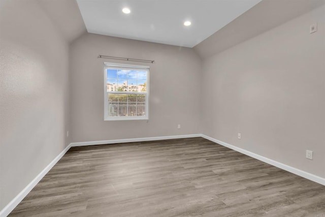 unfurnished room with lofted ceiling and light hardwood / wood-style flooring