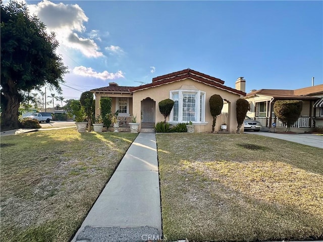 mediterranean / spanish-style home with a porch and a front lawn