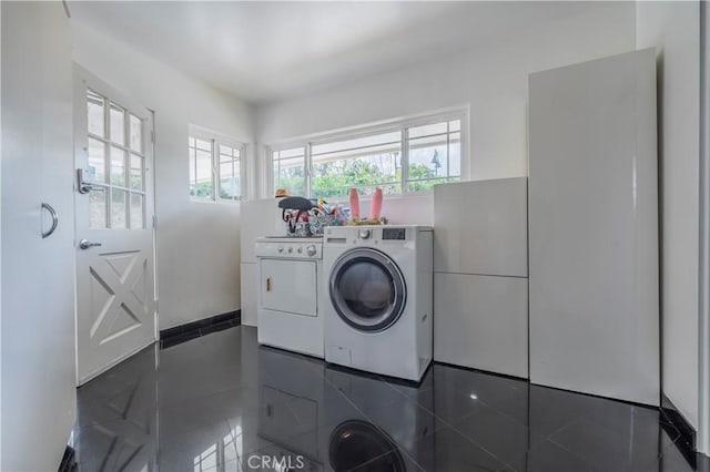 washroom featuring washer and clothes dryer and dark tile patterned floors