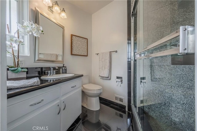 bathroom with vanity, an enclosed shower, tile patterned floors, and toilet