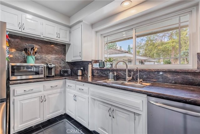 kitchen featuring tasteful backsplash, sink, white cabinets, and appliances with stainless steel finishes