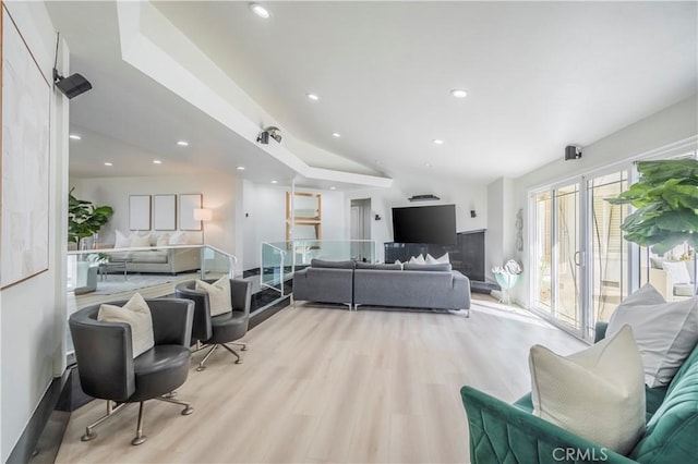 living room with lofted ceiling and light hardwood / wood-style flooring