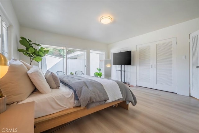 bedroom with light hardwood / wood-style flooring and access to outside