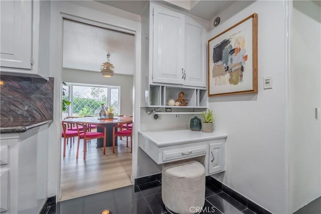 kitchen featuring dark tile patterned floors and white cabinets