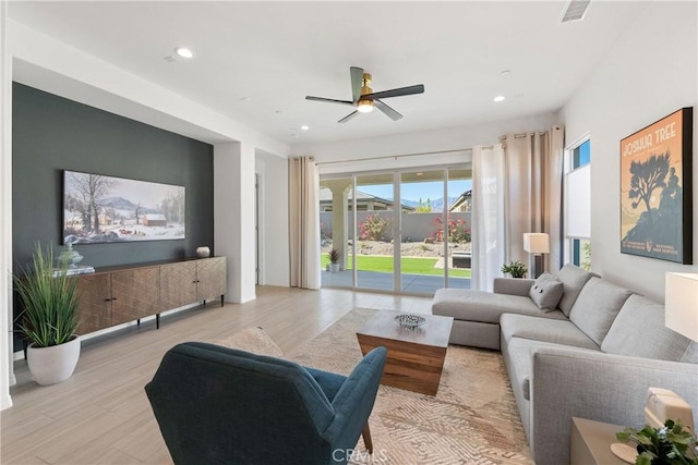 living room featuring light hardwood / wood-style floors and ceiling fan