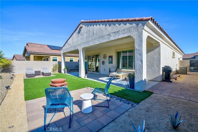 back of property with an outdoor hangout area, a yard, and a patio area