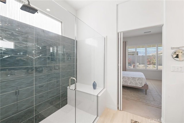 bathroom with a shower with door and hardwood / wood-style floors