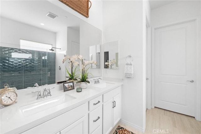 bathroom with vanity and a shower with door