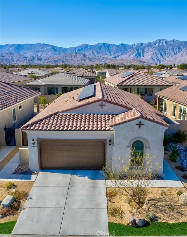 48 Vintage, Rancho Mirage, CA 92270 - mediterranean / spanish home featuring driveway, roof mounted solar panels, a tiled roof, a mountain view, and stucco siding