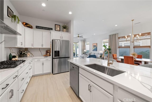 kitchen with pendant lighting, sink, white cabinetry, and appliances with stainless steel finishes