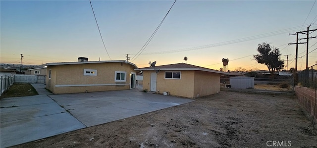 back house at dusk with a patio