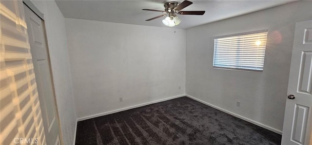 unfurnished room with ceiling fan and dark carpet