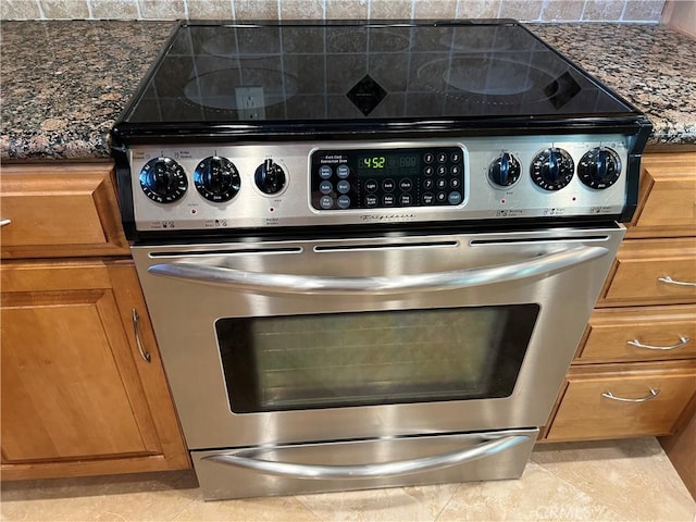 room details featuring dark stone countertops and electric range