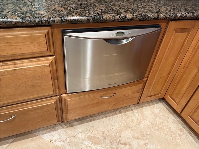 room details featuring stainless steel dishwasher and dark stone counters