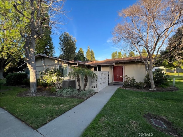 ranch-style home featuring central AC and a front yard