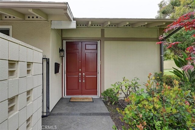 241 Calle Aragon Unit B, Laguna Woods, CA 92637 - view of exterior entry featuring stucco siding