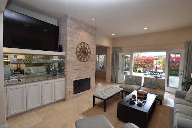 living room with a stone fireplace and sink