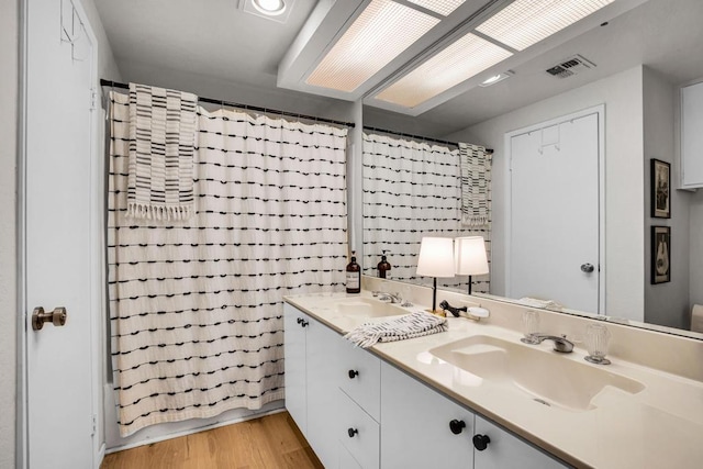 bathroom featuring hardwood / wood-style flooring, vanity, and shower / bath combination with curtain