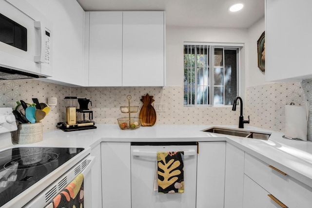 kitchen featuring sink, white cabinetry, dishwashing machine, decorative backsplash, and stove