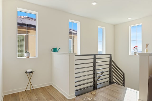 staircase with hardwood / wood-style flooring and a healthy amount of sunlight