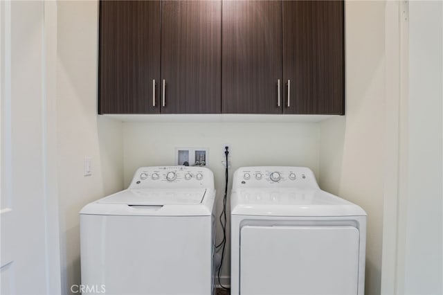 laundry room featuring cabinets and washer and clothes dryer