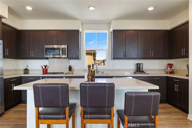 kitchen featuring dark brown cabinetry, a breakfast bar, and a kitchen island