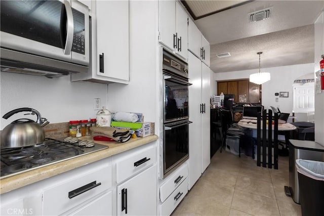 kitchen featuring stainless steel appliances, light tile patterned flooring, light countertops, and visible vents