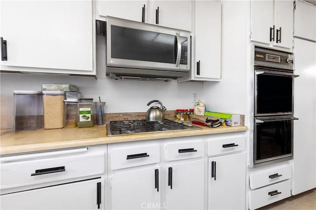 kitchen featuring white cabinetry, stainless steel appliances, and light countertops