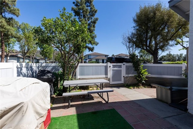 view of patio featuring area for grilling, a fenced backyard, and a gate