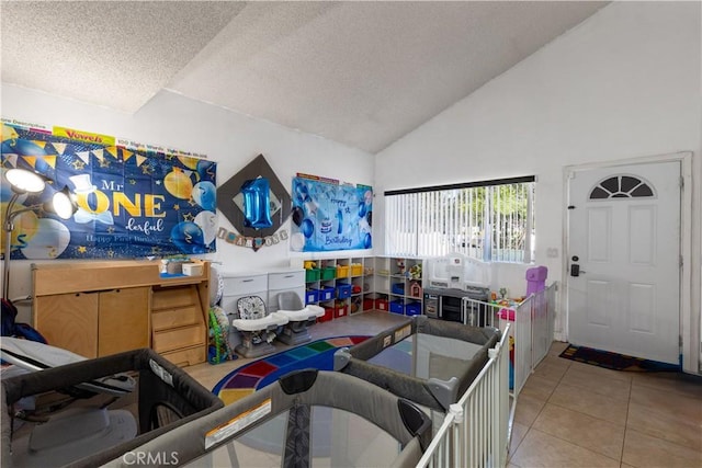 interior space with high vaulted ceiling, a textured ceiling, and tile patterned floors